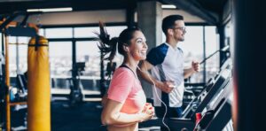 COUPLE TRAINING ON TREADMILLS IN A GYM